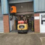 Man with a Van Coventry in the process of being loaded by a Forklift driving into open shutter doors to get the item to be loaded